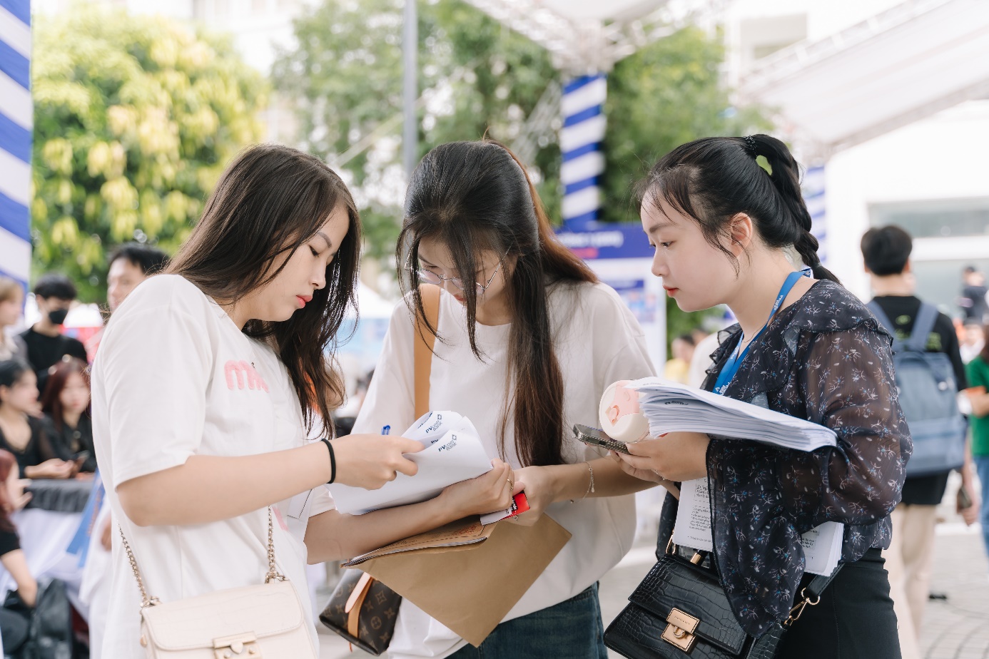 A group of women looking at papers Description automatically generated